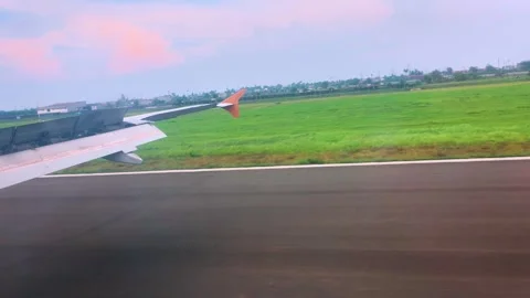 Passenger window perspective of aircraft wing on airport tarmac vibrant lan.. Stock-Footage 333840757