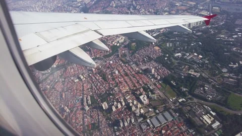 Passenger window showing an airplane wing with a red tip flying Stock-Footage 342623758
