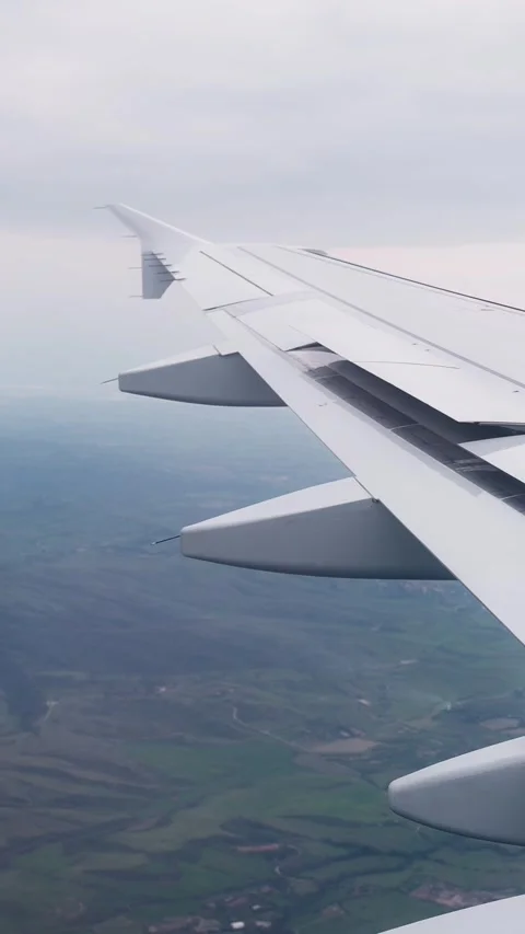 Passenger window view of an airplane wing in flight above patchwork Stock-Footage 336224739