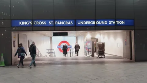 Passengers access Kings Cross St Pancras Underground Entrance at night 库存影片 334669292