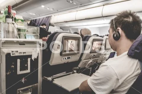 Passengers air travellers sitting in airplane cabin during inflight service Stock Photos