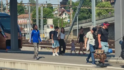 Passengers and commuters move through Bern Central Station on a bright summer Stock Footage 344032634