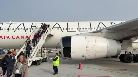 Passengers are disembarking from the plane. Air Canada Stock Footage 334766051
