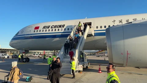 Passengers are disembarking from the plane parked on the airport apron Stock Footage 333941868