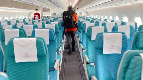 Passengers are walking down the aisle of the plane looking for their seats Stock Footage 170938414