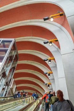 Passengers ascend an escalator inside the architecturally stunning Arden St.. Stock Photos