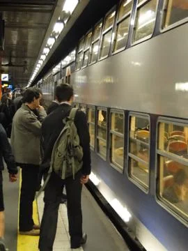 Passengers await the arrival of a train Stock Photos