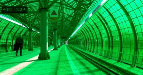 Passengers await the arrival of the train at the station of green glass Stock Footage 67468447