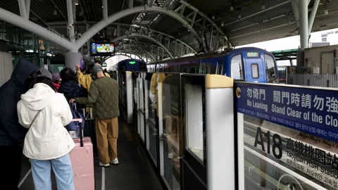 Passengers boarding Airport MRT train at Taoyuan HSR Station platform A18 Taiwan Stock Footage 334229455