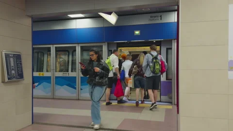 Passengers boarding metro train at Tre Torri station on Milan M5 line Stock Footage 336909829