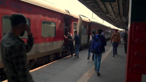 Passengers boarding a moving train at a railway station platform in Old Delhi Stock Footage 340270542