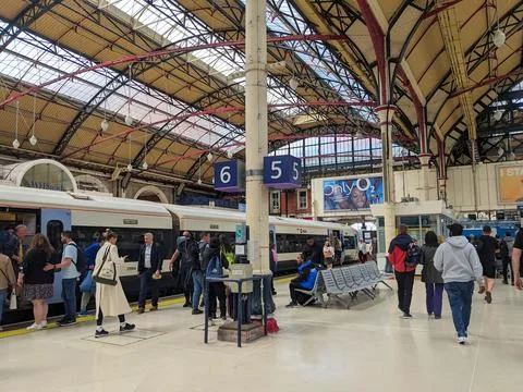 Passengers boarding a train on a platform while others heading to the exit at Stock Photos