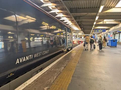 Passengers on a busy Euston train station platform alongside a modern Avanti Stock Photos