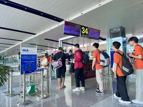 Passengers checking in for boarding at gate 34 near the carry-on luggage test Stock Photos