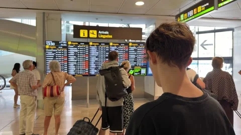 Passengers checking the flight arrivals board in Madrid Barajas Stockbeeldmateriaal 344584345