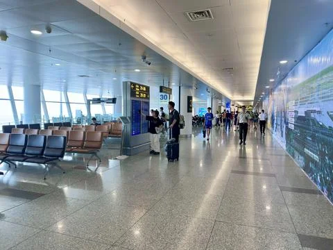 Passengers checking flight information on electronic boards at the modern Stock Photos