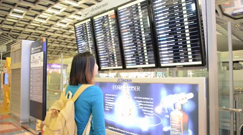 Passengers checking the flight schedule on airport charts Stock Footage 33785950