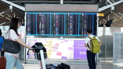 Passengers checking flight schedules at arrival departure board in airport Stock-Footage 91098049