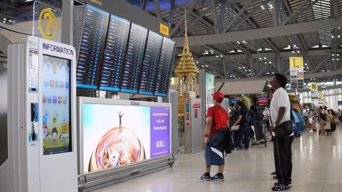 Passengers checking flight schedules at arrival departure board in airport Stock-Footage 91113544