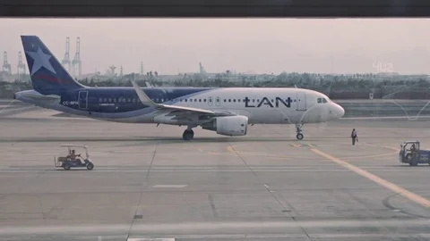 Passengers crossing the frame, LAN Airplane on the background Stock Footage 76374535