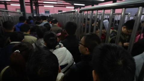 Passengers crowd through the fence to enter a subway station in Beijing Stock Footage 128413075