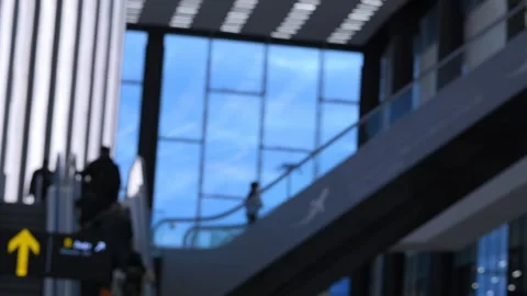 Passengers descend escalators under sleek glass architecture Stock Footage 343845646