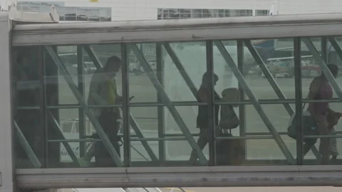 Passengers exiting airplane using the sky bridge Stock Footage 283222568