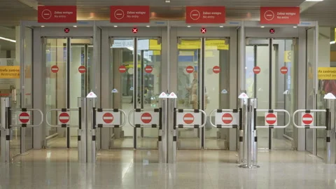 Passengers exiting through automatic one-way doors with No Entry signs Stock Footage 325032003