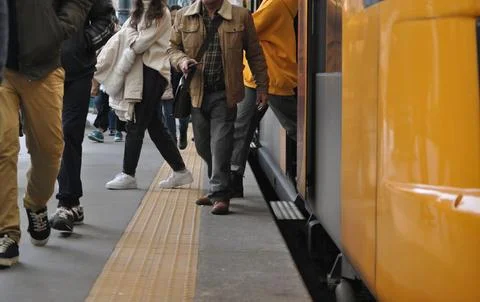 Passengers exiting a train at a station Stock Photos