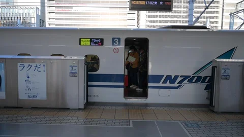 Passengers getting on a bullet train shinkansen bound for Tokyo. Stock Footage 128288269