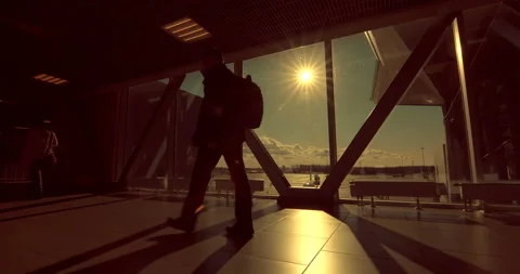 Passengers go through the glass passage where the runway with planes Stock Footage 119604016