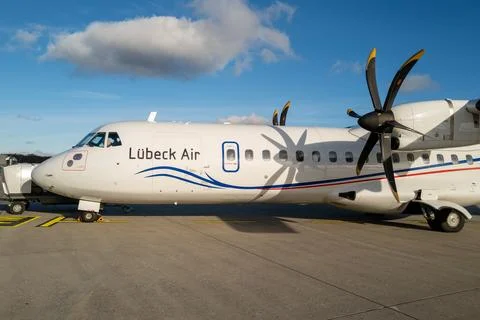 Passengers go to the white propeller plane of Luebeck Air at Luebeck Airport Stock Photos