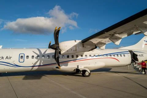 Passengers go to the white propeller plane of Luebeck Air at Luebeck Airport Stock Photos