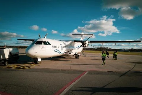 Passengers go to the white propeller plane of Luebeck Air at Luebeck Airport Stock Photos