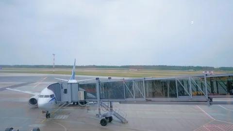 Passengers going down to airplane through the air bridge. Video stock 97255138