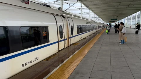Passengers happily walking to the approaching high-speed bullet train Video stock 290486107
