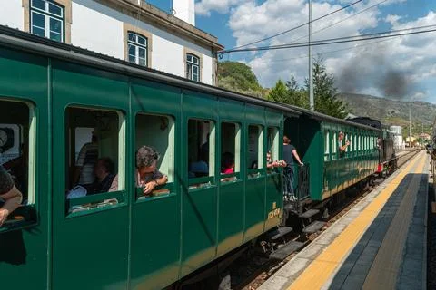Passengers inside a vintage green train stopped at Tua railway station Stock Photos