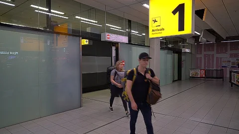 Passengers leaving the arrivals hal Stock Footage 90358024