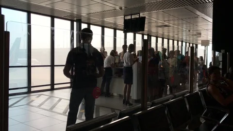 Passengers lined up for boarding at the gate provide documents to hostesses. Stock Footage 94139916