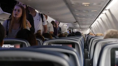 Passengers loading airplane walking down aisle 스톡 동영상 105923877