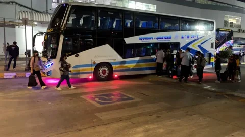 Passengers loading backpack on double decker bus at Bangkok bus terminal night Video stock 189449402