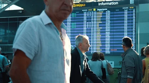 Passengers looking at timetable board screen at the airport, international Stock Footage 97143298