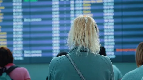 Passengers looking at timetable board screen at the airport, international Stock Footage 97143455
