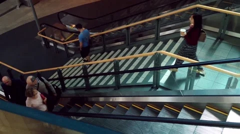 Passengers with luggage taking escalator inside YVR airport Stock Footage 50331472