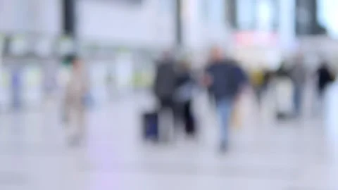 Passengers navigate bustling public space with rolling suitcases Stock Footage 343563309