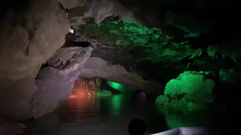 Passengers navigate a narrow water passage inside Prometheus Cave Stock Footage 340387245