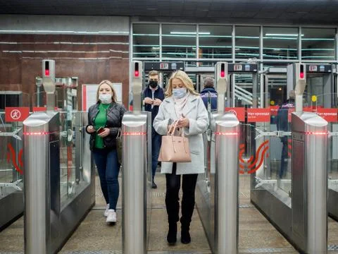 Passengers pass through automatic turnstiles at the Moscow metro station. Stock Photos