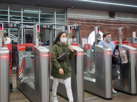 Passengers pass through automatic turnstiles at the Moscow metro station. Stock Photos
