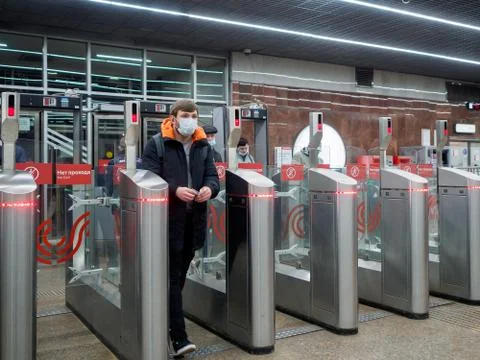 Passengers pass through automatic turnstiles at the Moscow metro station. Stock Photos