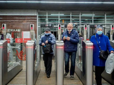 Passengers pass through automatic turnstiles at the Moscow metro station. Stock Photos